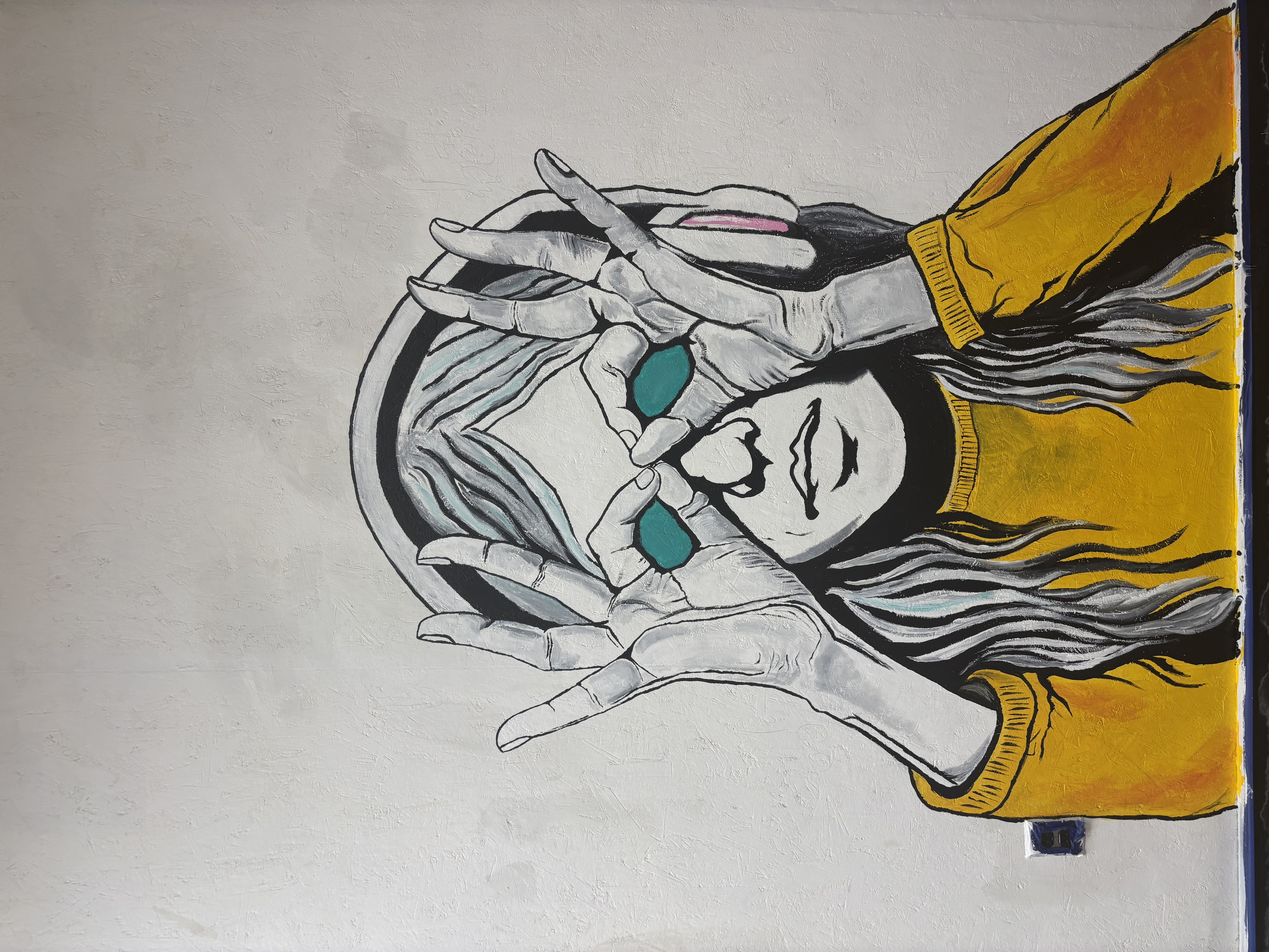 Mural painting of hands framing a face